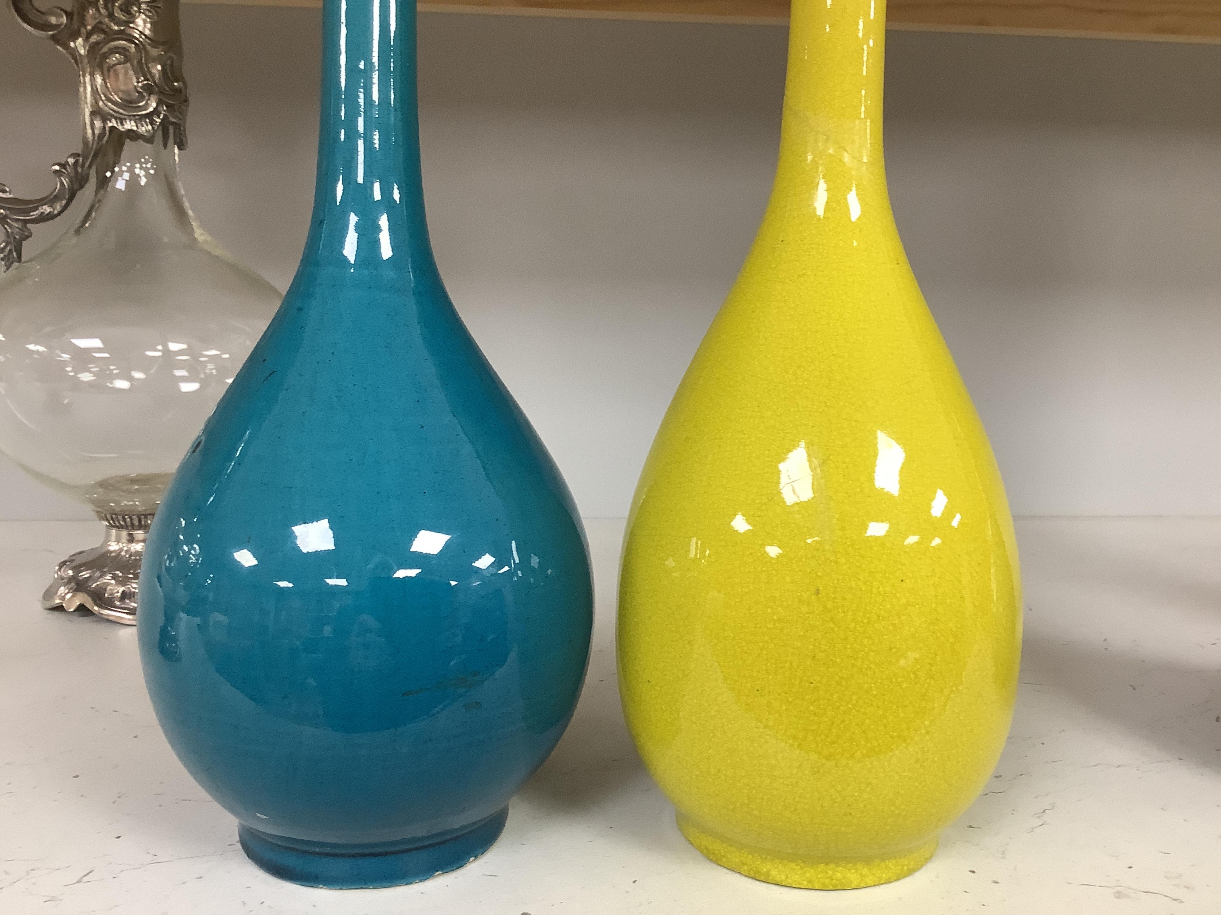 A late 19th century Japanese turquoise glazed narrow neck bottle vase, 31cm high, a smaller similar vase, 22cm high and a tall yellow glazed vase, 31cm high. Condition - repair to neck of yellow vase